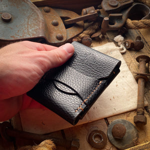 All Black handmade leather flap wallet in hand
